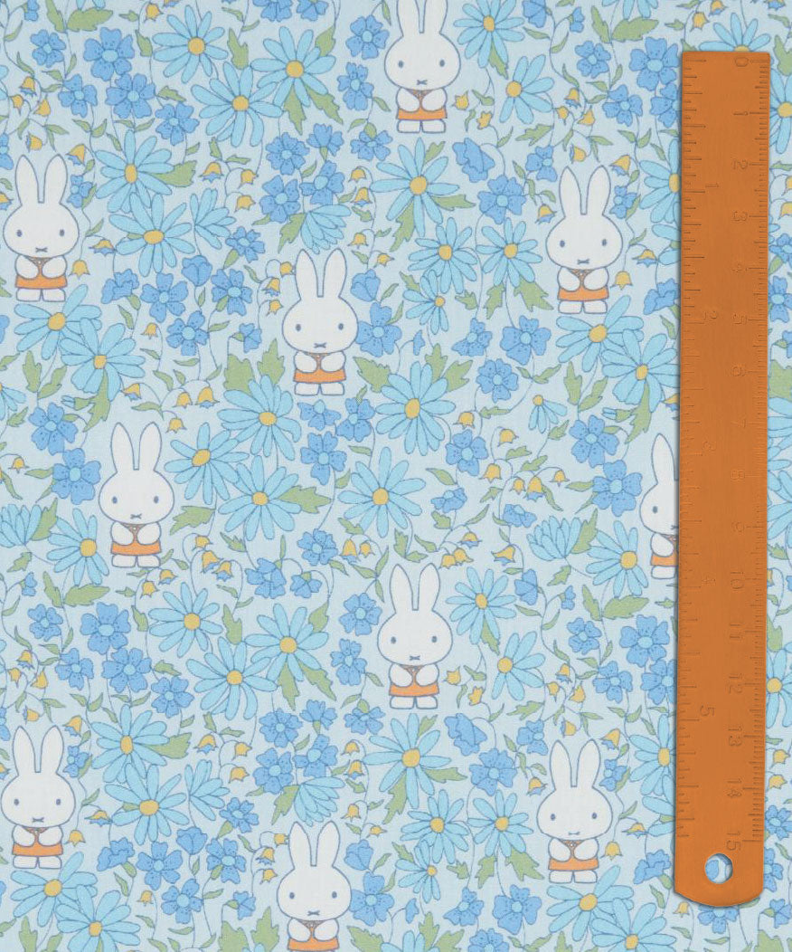 Liberty x Miffy Prairie Day Tana Lawn in pale sky blue, with cornflowers and blue daisies, shown with a ruler for scale