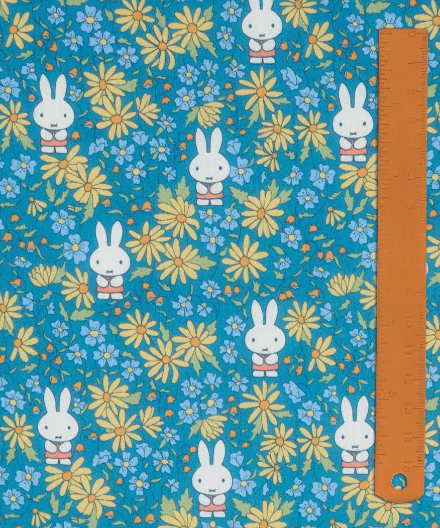 Liberty x Miffy Prairie Day Tana Lawn in bright teal, with golden daisies, shown with a ruler for scale