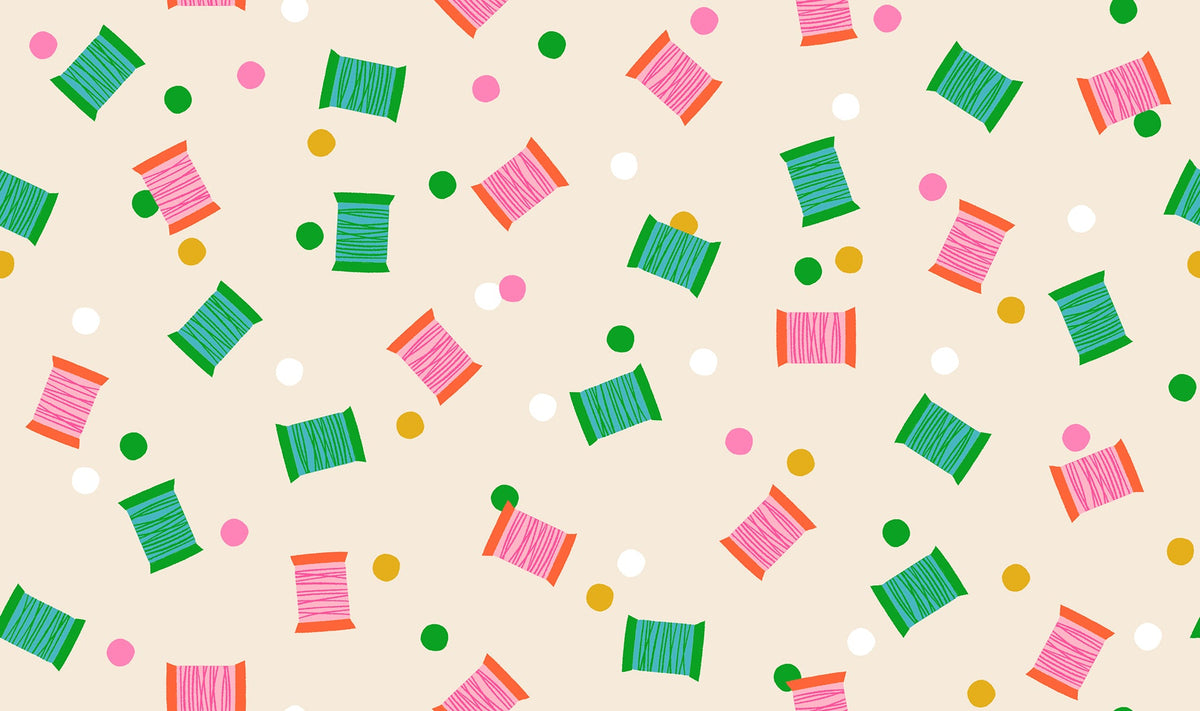 Spools in Shell quilting cotton by Ruby Star Society — spools of thread tossed across the cloth in a rainbow of colours on a soft blush pink