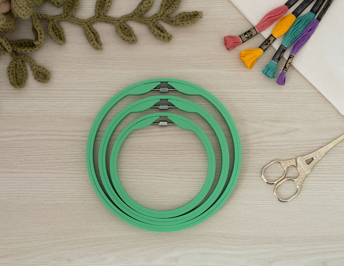 Matte Grass Green embroidery hoops styled with fabric, thread and scissors