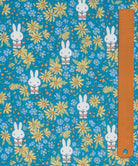 Liberty x Miffy Prairie Day Tana Lawn in bright teal, with golden daisies, shown with a ruler for scale