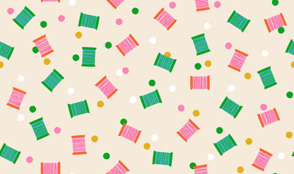 Spools in Shell quilting cotton by Ruby Star Society — spools of thread tossed across the cloth in a rainbow of colours on a soft blush pink