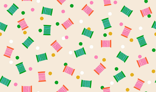 Spools in Shell quilting cotton by Ruby Star Society — spools of thread tossed across the cloth in a rainbow of colours on a soft blush pink