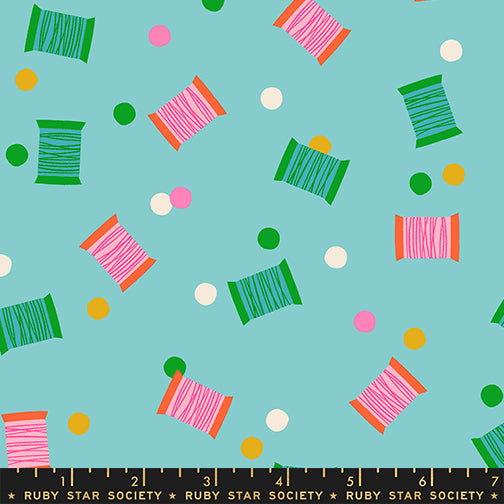 Spools in Cloudless quilting cotton by Ruby Star Society — spools of thread tossed across the cloth in a rainbow of colours on a clear sky blue — pattern repeat